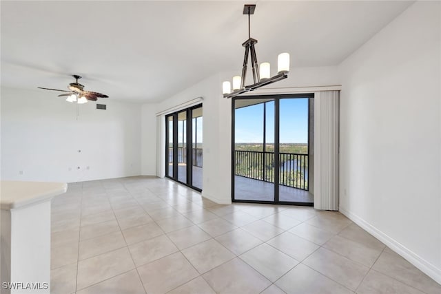 unfurnished room featuring light tile patterned flooring and ceiling fan with notable chandelier