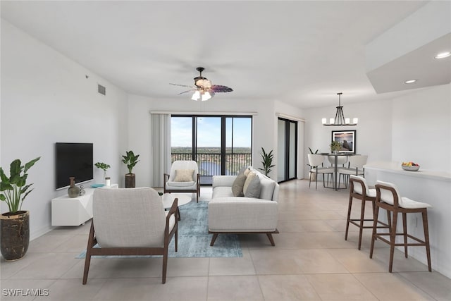 living room with light tile patterned floors and ceiling fan with notable chandelier