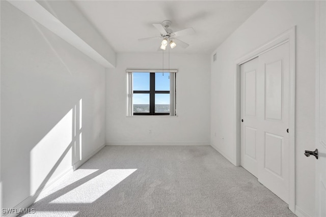 carpeted spare room with ceiling fan