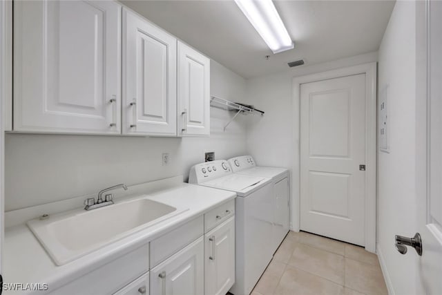 clothes washing area with light tile patterned floors, cabinets, sink, and washing machine and clothes dryer