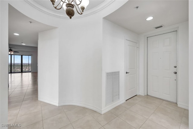 hall with light tile patterned flooring and a notable chandelier