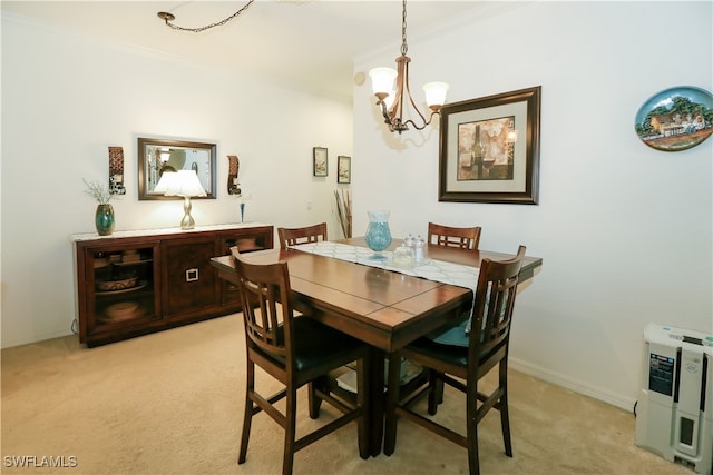 dining space featuring ornamental molding, a chandelier, and light carpet