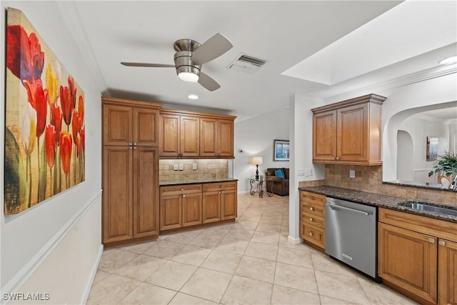 kitchen featuring stainless steel dishwasher, brown cabinetry, a sink, and visible vents