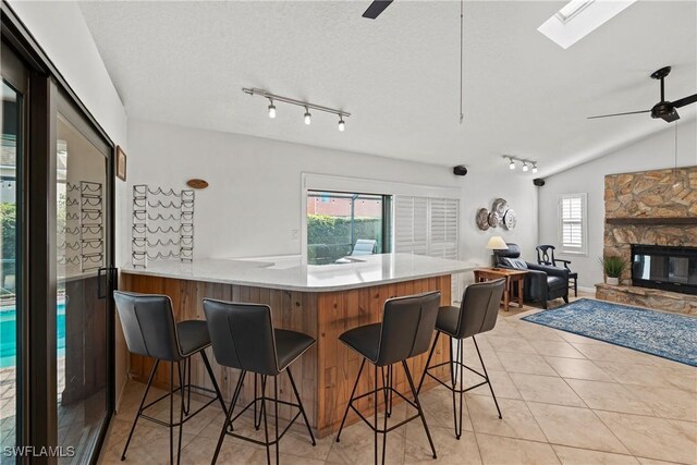 kitchen featuring a kitchen breakfast bar, kitchen peninsula, ceiling fan, and plenty of natural light