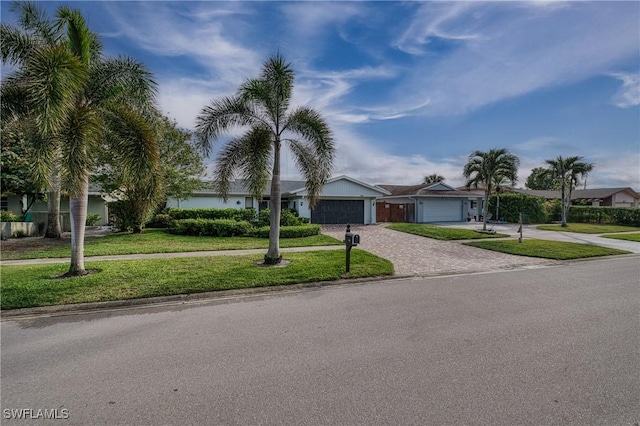 view of front of property featuring a garage, a residential view, a front lawn, and decorative driveway