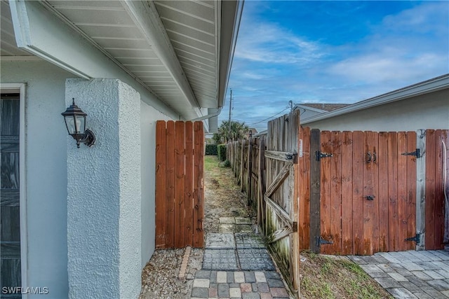 view of home's exterior featuring fence, a gate, and stucco siding