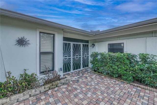 entrance to property with a patio area and stucco siding