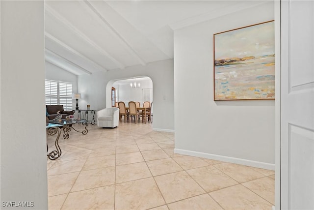 interior space with tile patterned flooring, vaulted ceiling with beams, baseboards, and arched walkways