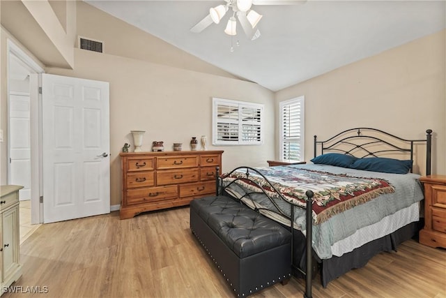 bedroom with light wood-style floors, vaulted ceiling, visible vents, and a ceiling fan