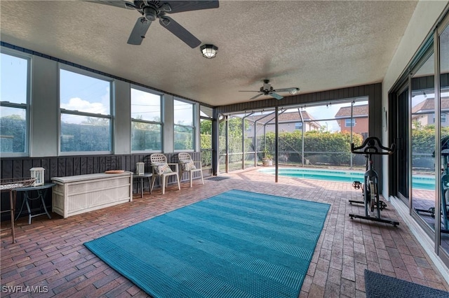 sunroom with a pool and a ceiling fan