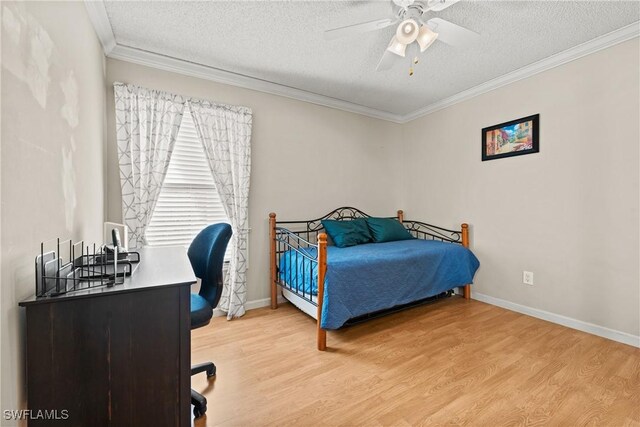 bedroom featuring hardwood / wood-style floors, a textured ceiling, ceiling fan, and ornamental molding