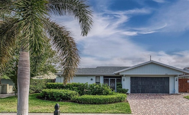 single story home featuring a garage, decorative driveway, and stucco siding