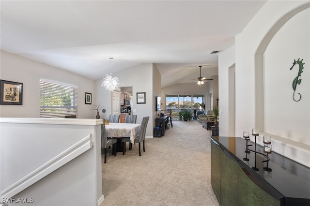 dining space with light carpet, ceiling fan with notable chandelier, and lofted ceiling