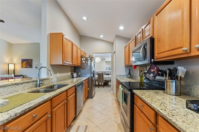 kitchen with light stone countertops, appliances with stainless steel finishes, vaulted ceiling, sink, and light tile patterned floors