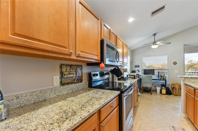 kitchen featuring light stone countertops, appliances with stainless steel finishes, vaulted ceiling, ceiling fan, and light tile patterned floors