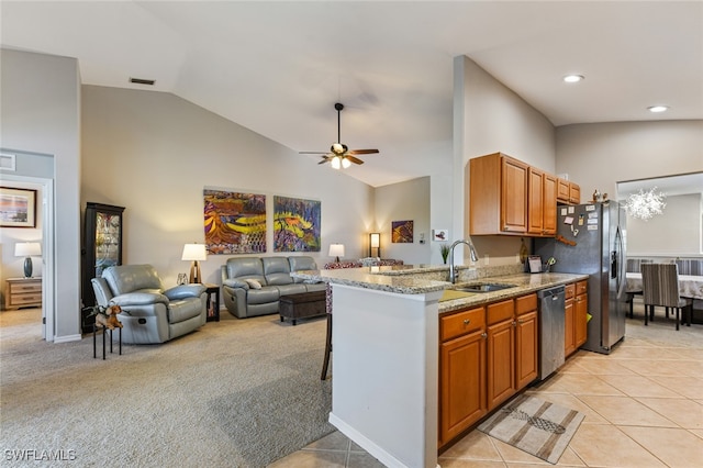 kitchen with light carpet, ceiling fan with notable chandelier, sink, appliances with stainless steel finishes, and kitchen peninsula