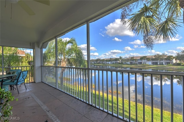 unfurnished sunroom with ceiling fan and a water view