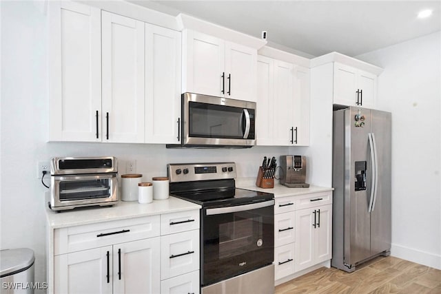 kitchen featuring white cabinetry, stainless steel appliances, and light hardwood / wood-style floors