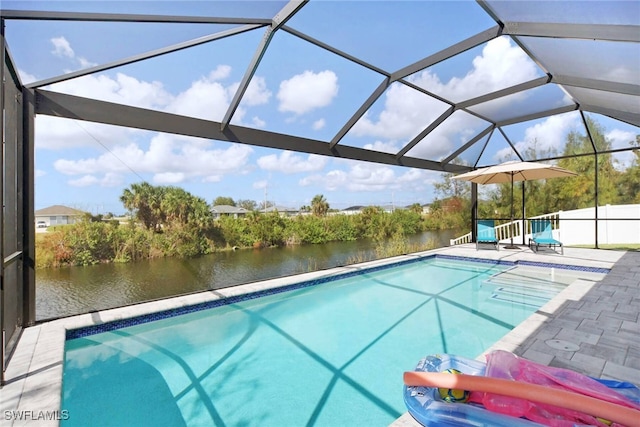 view of swimming pool featuring glass enclosure, a patio area, and a water view