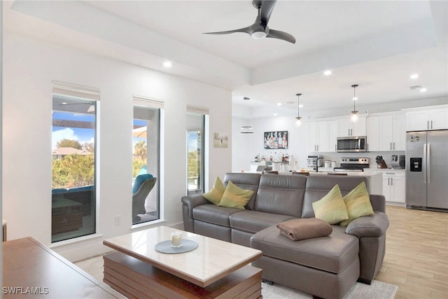 living room featuring ceiling fan and light hardwood / wood-style flooring