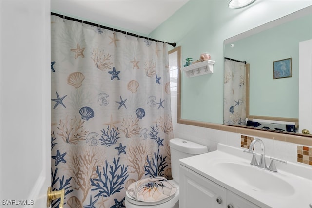 bathroom with a shower with curtain, vanity, toilet, and tile walls