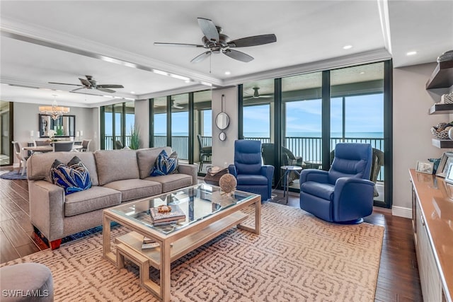 living room with ceiling fan with notable chandelier, a wealth of natural light, a water view, and hardwood / wood-style flooring