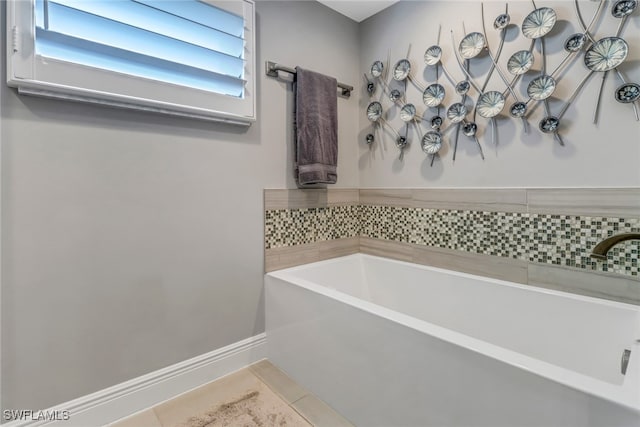 bathroom with a bath and tile patterned floors