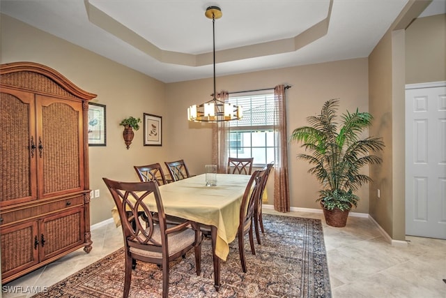 dining room featuring a tray ceiling and an inviting chandelier