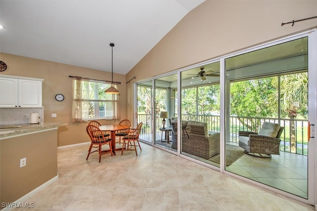 tiled dining space featuring high vaulted ceiling and ceiling fan