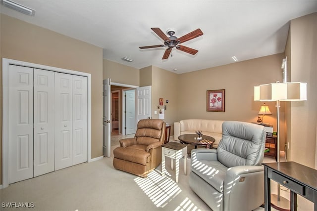 carpeted living room with ceiling fan