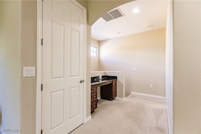 corridor featuring light colored carpet