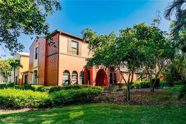 mediterranean / spanish house with a front lawn