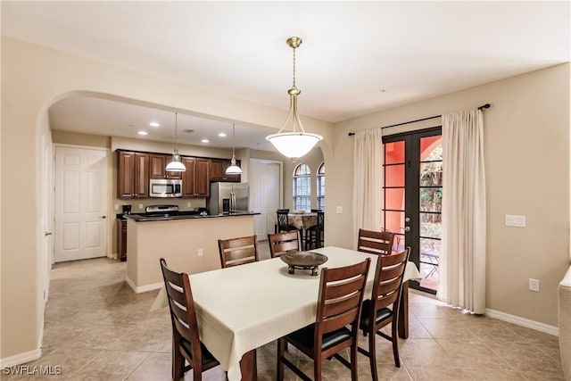 9028 Alturas St Unit 3204, Naples, FL 34113 - dining room featuring arched walkways, baseboards, light tile patterned flooring, and recessed lighting