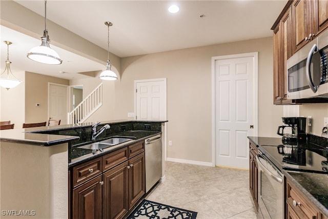 kitchen featuring sink, light tile patterned flooring, stainless steel appliances, and decorative light fixtures