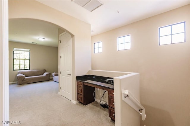 9028 Alturas St Unit 3204, Naples, FL 34113 - hall with light colored carpet, arched walkways, a desk, and baseboards