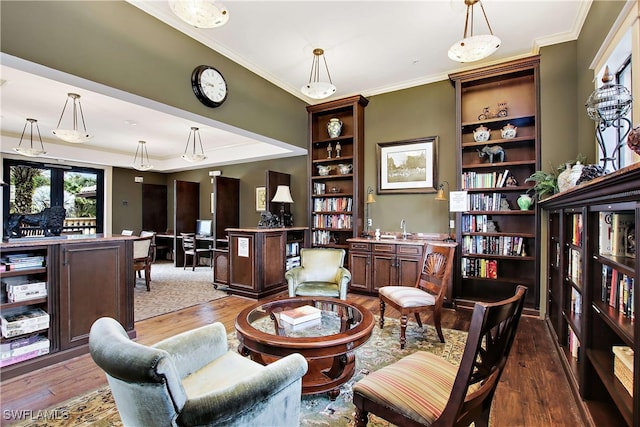 living area featuring hardwood / wood-style floors, ornamental molding, and sink