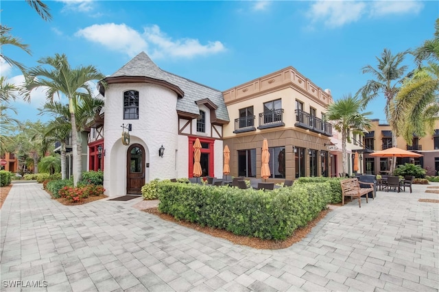 9028 Alturas St Unit 3204, Naples, FL 34113 - view of front facade featuring stucco siding, a balcony, and mansard roof
