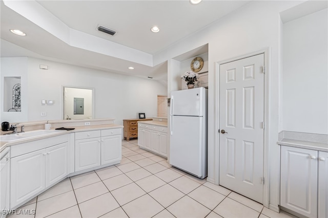 kitchen featuring light tile patterned flooring, white appliances, white cabinetry, and sink