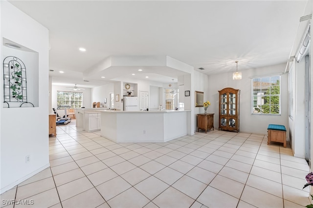 kitchen with white cabinets, white fridge, light tile patterned floors, and pendant lighting