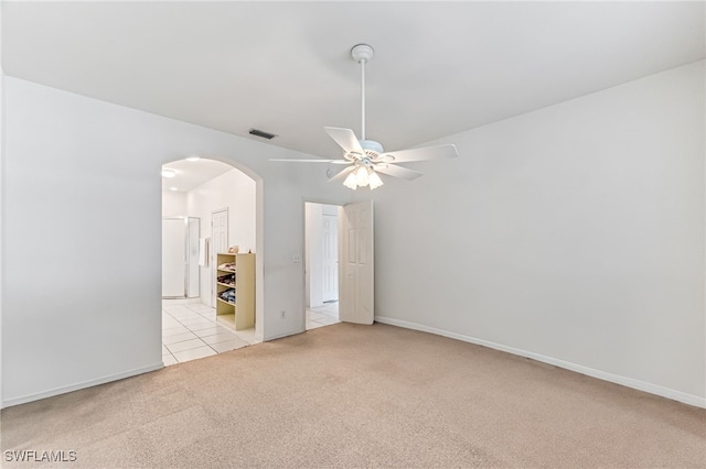 empty room with ceiling fan and light carpet