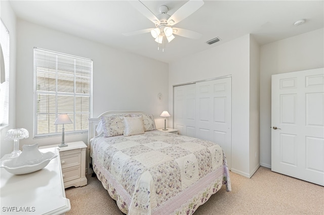 bedroom featuring light carpet, a closet, and ceiling fan