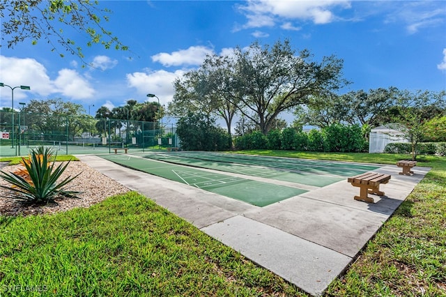 view of home's community featuring a yard and tennis court