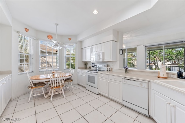 kitchen with sink, white cabinets, light tile patterned flooring, and white appliances