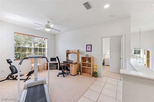 carpeted home office featuring ceiling fan with notable chandelier