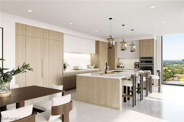 5100 Baybridge Blvd Unit 1601, Estero, FL 33928 - kitchen featuring modern cabinets, a kitchen breakfast bar, light countertops, double oven, and a kitchen island with sink