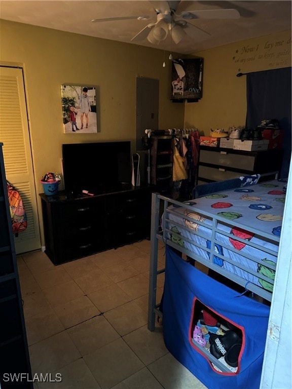 tiled bedroom featuring ceiling fan and a closet