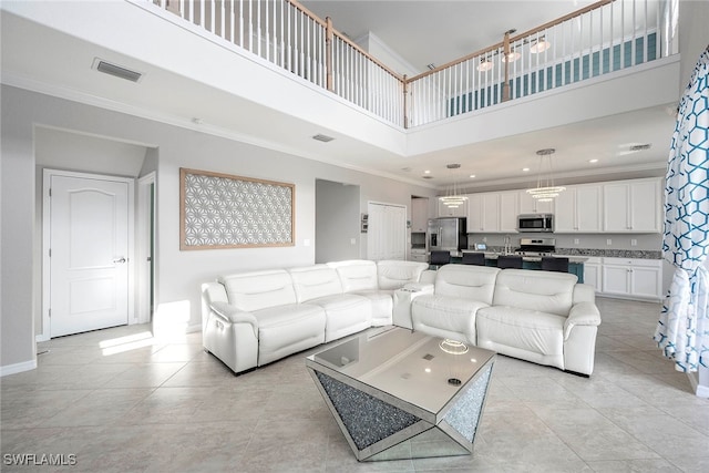 tiled living room featuring a high ceiling and ornamental molding