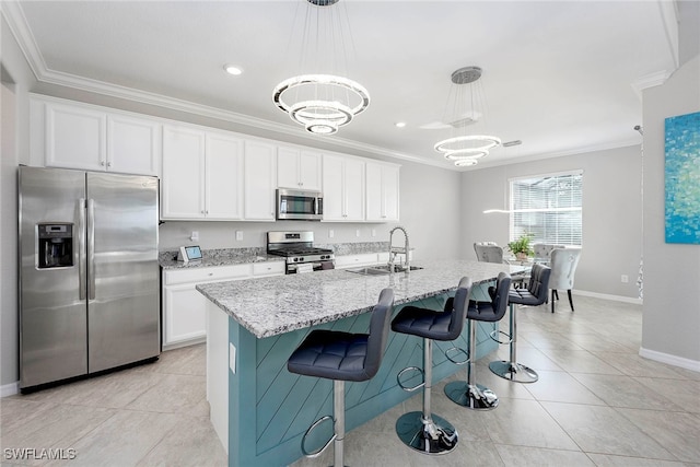 kitchen featuring sink, hanging light fixtures, stainless steel appliances, a center island with sink, and white cabinets