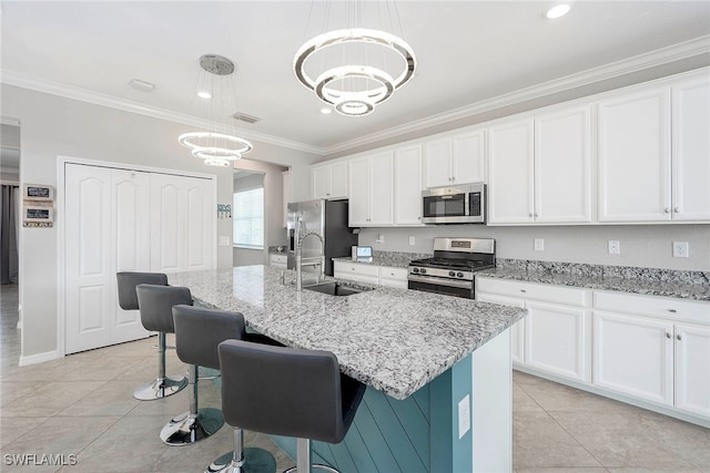 kitchen with hanging light fixtures, a kitchen island with sink, sink, and stainless steel appliances