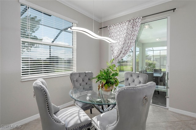 tiled dining space with ornamental molding and a healthy amount of sunlight